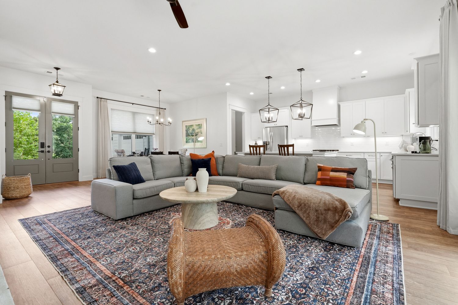 Open-concept living room with sectional and forest views